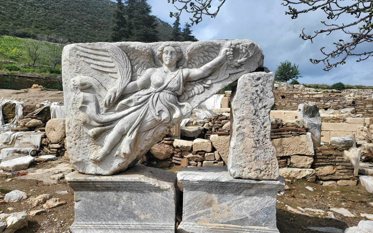 The carved relief of the winged goddess Nike lying among blocks at Domitian Square in Ephesus